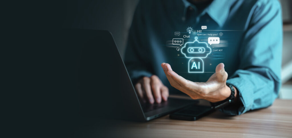 Photograph of a man on a laptop with his hand open, showing a graphic of an AI robot.