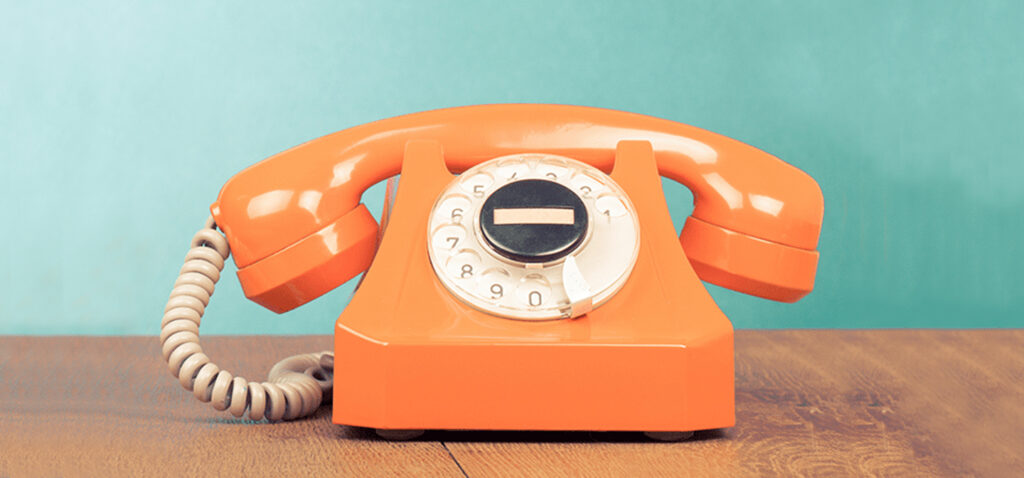Orange telephone on a desk - PSTN benefits