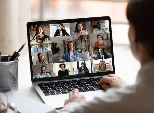 A video call in progress. Several people on a laptop screen.